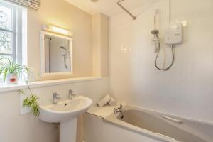 a white bathroom with a sink and a bath tub at 2 Bed in Bressingham oc-f33646 in Bressingham