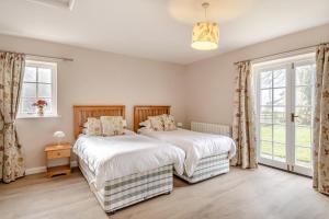 two beds in a bedroom with two windows at 2 Bed in Bressingham oc-f33646 in Bressingham