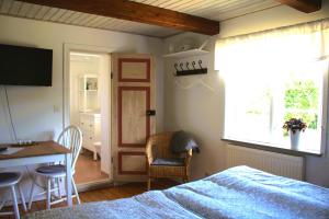 a bedroom with a bed and a table and a desk at Landet Bed and Breakfast in Tomelilla