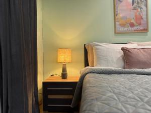 a bedroom with a bed and a lamp on a night stand at Odessa Guest House-City Center in Chişinău