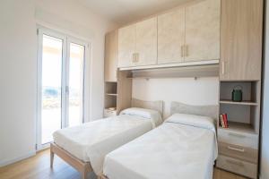 two beds in a room with a window at Villa Adele con piscina privata vicino Tropea - per 16 persone in Torre Marino +42 photos