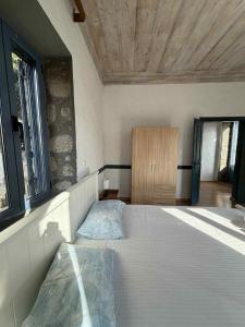 a bedroom with a bed and a wooden ceiling at Kontias stonehouses in Kondiás