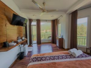 a bedroom with a bed and a flat screen tv at Dream Stay Green in Nuwara Eliya