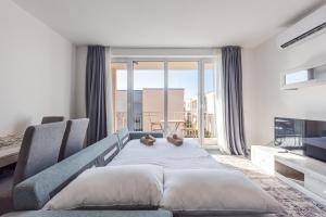 a bedroom with a blue bed and a large window at Serene Haven Talea by PikHost in Tale +32 photos