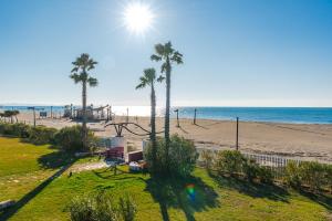 a view of a beach with palm trees and a playground at Serene Haven Talea by PikHost in Tale