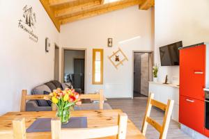 a dining room and living room with a wooden table at Beim Huber in Hopferau