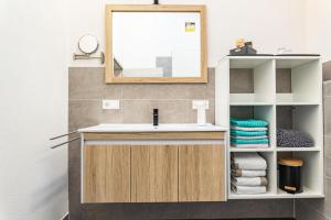 a bathroom with a sink and a mirror and towels at Beim Huber in Hopferau +29 photos
