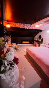 a room with two beds and a fireplace with flowers at La suite des cœurs cachés in Valserres