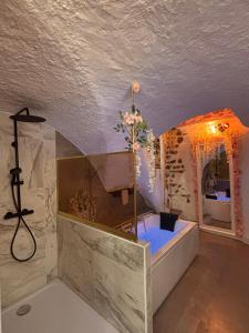 a bathroom with a shower with a blue tub at La suite des cœurs cachés in Valserres
