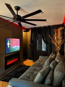 a living room with a ceiling fan and a fireplace at La suite des cœurs cachés in Valserres