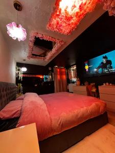 a bedroom with a large bed and a tv at La suite des cœurs cachés in Valserres