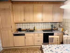 a kitchen with wooden cabinets and a sink and a table at Movika in Neef