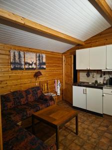 a living room with a couch and a table at Lidens Stugby in Vaggeryd