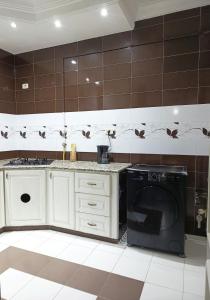 a kitchen with a washing machine in a room at modern apartment in Akouda