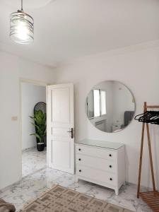 a white room with a white dresser and a mirror at modern apartment in Akouda