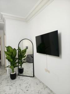 a living room with a mirror and a tv on a wall at modern apartment in Akouda
