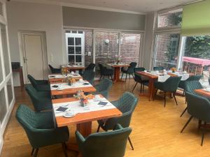 a dining room with tables and chairs and windows at Altes Gasthaus Stover in Löningen