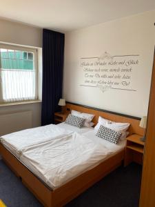 a bedroom with a bed with white sheets and pillows at Altes Gasthaus Stover in Löningen