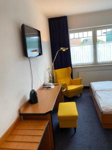 a hotel room with a bed and a desk and a tv at Altes Gasthaus Stover in Löningen