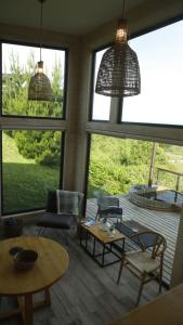 a living room with chairs and tables and large windows at Parcela Nueve in Frutillar