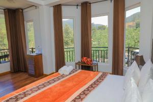 a bedroom with a bed and a balcony with windows at Dream Stay Green in Nuwara Eliya