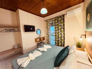 a bedroom with a blue bed with a television and a couch at Sarita's Apartments & Suite in Laganas