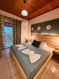 a bedroom with a large bed with towels on it at Sarita's Apartments & Suite in Laganas