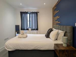a bedroom with a bed with a teddy bear on it at Two Bedroom Flat with Ensuite Bathrooms in Hemel Hempstead