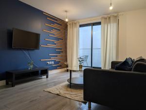 a living room with a couch and a flat screen tv at Two Bedroom Flat with Ensuite Bathrooms in Hemel Hempstead