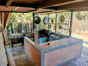 an outdoor kitchen with a sink and a stove at Spacious Garden Villa, private pool, huge grounds with orange trees in Dos Hermanas