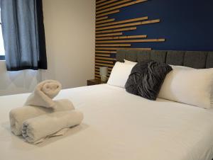 a stuffed teddy bear sitting on a bed at Two Bedroom Flat with Ensuite Bathrooms in Hemel Hempstead