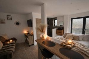 a bedroom with a bed and a table with candles at Studio avec spa vue Moselle in Dinozé