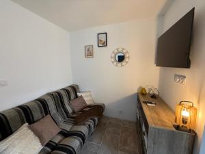 a living room with a couch and a tv at Studio avec spa vue Moselle in Dinozé
