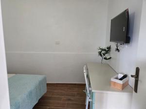 a small room with a bed and a desk with a tv at La Perlita in Las Eras