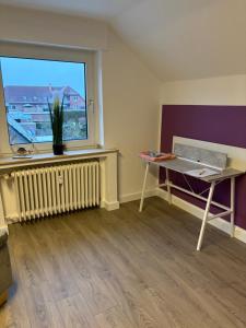 a room with a desk and a window and a table at Red Dot Apartment Bruno in Werne an der Lippe +7 photos