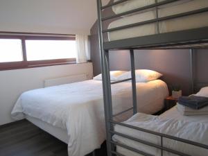 a bedroom with two bunk beds and a window at Allongueroye in Houffalize