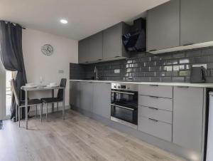 a kitchen with white cabinets and a table with chairs at The Cabin - Private Car Park with CCTV - Fast WiFi - Peaceful Retreat with Views for Business or Couples in Oldbury