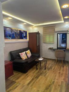a living room with a black couch and a table at Hotel Annasr in Chefchaouen