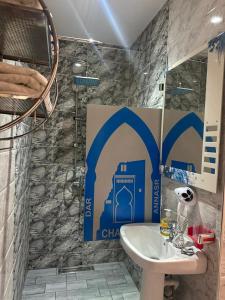 a bathroom with a sink and a shower at Hotel Annasr in Chefchaouen