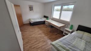 a room with a bed and a desk and a bed sidx sidx sidx at Komfort Apartment 2 EG bei Jürgen Kunzi in Filderstadt