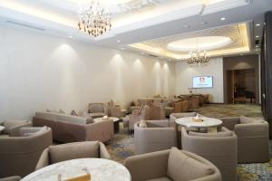 a waiting room with chairs and tables and a chandelier at Darin Plaza Hotel in Erbil