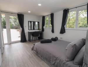 a bedroom with a bed and a couch and windows at The Cabin - Private Car Park with CCTV - Fast WiFi - Peaceful Retreat with Views for Business or Couples in Oldbury