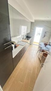 a kitchen with a refrigerator and a wooden floor at Alojamento Numara in Setúbal +23 photos
