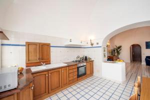a kitchen with wooden cabinets and a tile floor at Casa Rosamare, 150 stairs from the road by Wonder Tour in Praiano