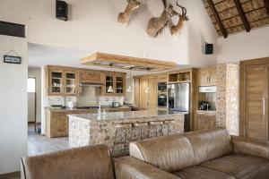 an open kitchen with a large island and leather furniture at 22 Siyanda Mabalingwe in Mabula