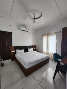 a bedroom with a large bed and a desk at Raj Embassy in Rudrapur