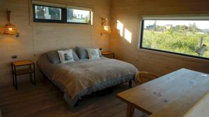 a bedroom with a bed and a table and a window at Parcela Nueve in Frutillar