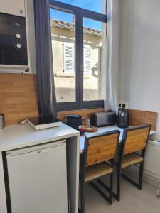 a kitchen with a table and chairs and a window at Studio lumineux Avignon centre, proche de tout in Avignon