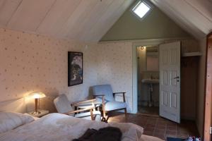 a bedroom with a bed and a chair and a table at Alunbruket B & B in Brösarp