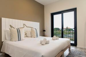 a bedroom with a large white bed with a large window at WOT Ericeira Surf Social in Ericeira +98 photos